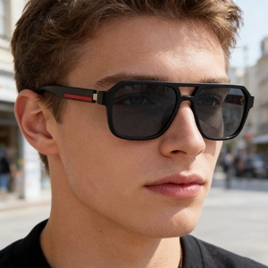 Detail view of square pilot sunglasses with red stripe accent on matte black temples
