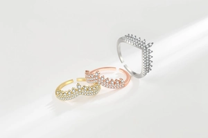 Detailed view of crown and V-shaped stackable rings in gold, rose gold and silver colors