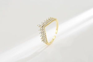 Macro detail of gold crown V-shape ring with pavé-set sparkling zircons and open band