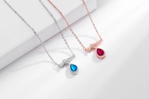 Detailed shot of teardrop gemstone necklaces in blue and red with crystal accents