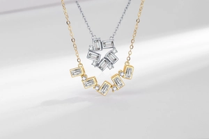 Macro view of minimalist V-shaped and circular zircon necklaces in gold and silver plating