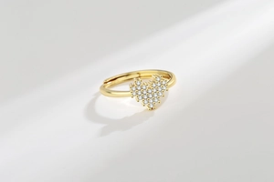 Close-up of heart-shaped gold ring with pavé white zircon and adjustable open band