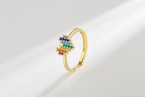 Detail view of rainbow cubic zirconia heart ring with an adjustable gold-plated band