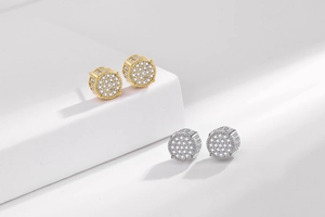 Détail de boucles d'oreilles hiphop pavées de zircons en finitions or et argent