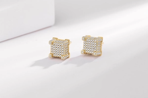 Gros plan de boucles d'oreilles carrées hip-hop dorées avec pavage de zircons cubiques