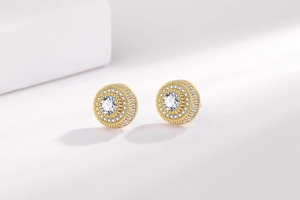 Détail macro de boucles d'oreilles halo rondes dorées avec oxydes de zirconium scintillants