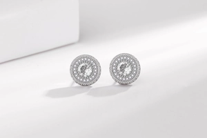 Vue macro de boucles d'oreilles hip-hop en argent avec zircone centrale et double halo