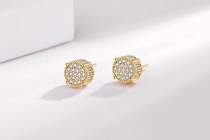 Détails macro des boucles d'oreilles hip hop dorées avec zircons micro-pavés
