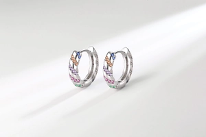 Macro detail of silver hoop earrings featuring pavé-set colorful rainbow cubic zirconia