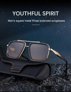 Close-up of square polarized sunglasses with gold metal frame on a dark rock