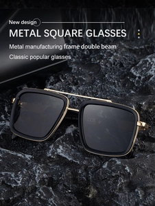 Close-up of gold metal double bridge square sunglasses on rugged dark rock background