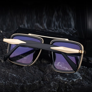 Detail of retro polarized sunglasses with double bridge and black gold square frame