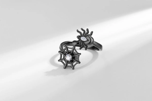 Vue détaillée d'une bague araignée en métal noir avec zircone blanche et toile d'araignée