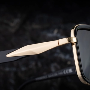 Macro view of double-bridge square sunglasses showing hinge detail and metal diamond trim