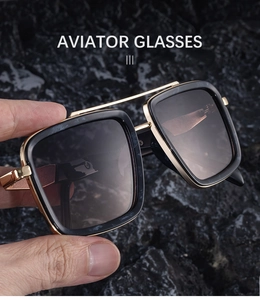 Detail of aviator glasses with bold black frames, gold bridge and gradient lenses