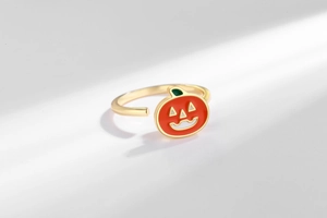Close-up of rotatable orange pumpkin ring with adjustable golden band for anxiety relief