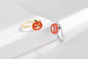 Detail view of pumpkin spinner rings with orange enamel and adjustable open band