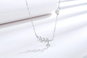 Vue macro du pendentif feuille en argent avec cristaux et lettres Love sur chaîne