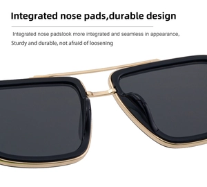 Macro shot of double-bridge sunglasses featuring integrated nose pads and gold metal frame