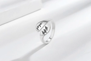 Detailed view of silver ring featuring engraved mountain peaks and forest tree patterns
