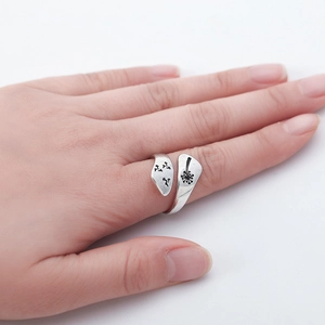 Close-up of vintage silver dandelion ring with adjustable open band on woman's hand
