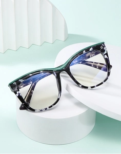 Detail of cat-eye eyewear frame with blue marble pattern and green streamline accents