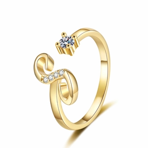 Macro shot of gold adjustable letter ring with round centerpiece and side diamonds