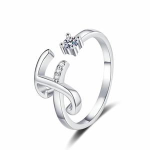 Detail of adjustable silver letter ring featuring a large zircon and three small accents