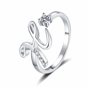 Macro detail of silver letter H ring featuring sparkling zircons and a round center stone