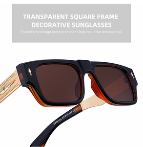 Detailed close-up of square sunglasses with gold metal temples and feather pattern engraving