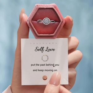 Classic silver halo ring with pavé diamonds in a pink velvet box with card