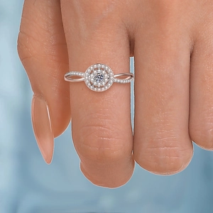 Rose gold engagement ring with cluster center and twisted diamond band on finger