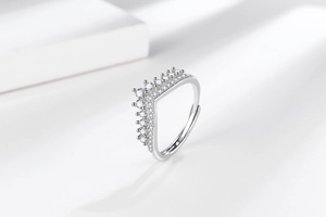 Detailed close-up of zircon-encrusted crown ring with silver finish and adjustable band