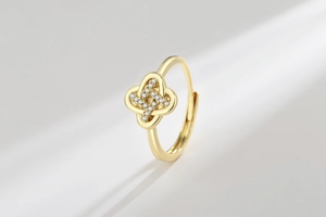 Macro shot of gold-plated clover ring with white zircon stones and adjustable open band