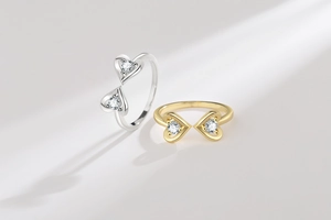 Detailed view of gold and silver open rings featuring double heart-shaped zircons