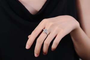 Detailed close-up of a silver four-leaf clover ring with sparkling zircon stones on a finger