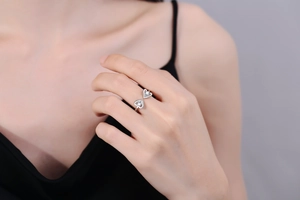 Detailed close-up of double heart zircon ring in silver on a fashion model's finger