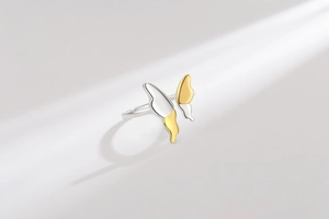Detail of bicolored butterfly open ring with polished gold and silver mirror finish