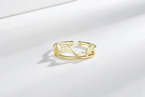 Détail de la bague montagne dorée réglable avec un design minimaliste et poli miroir