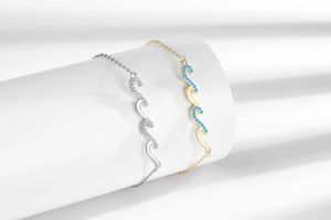 Macro detail of gold and silver wave bracelets with sparkling blue and clear crystals