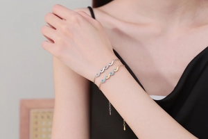 Close-up of stacked gold and silver wave bracelets with sparkling crystals on a wrist