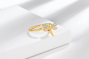Detail of golden spinning dragonfly ring with colorful crystals and twisted band