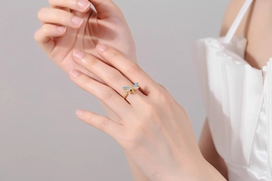 Detailed close-up of a rotating dragonfly ring with colorful cubic zirconia and twisted band