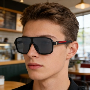 Detail of modern black square sunglasses with iconic red stripe on the temple arm