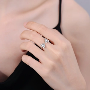 Minimalist silver open ring with double heart-shaped zircons on a model's hand
