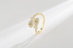 Macro detail of gold fish rings with white cubic zirconia and blue gemstone eyes