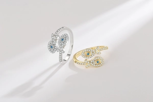 Detail view of fish-shaped open rings with pavé zircon and blue gemstone eyes