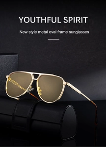 Detail of pilot sunglasses with gold metal frame and light brown lenses on leather case