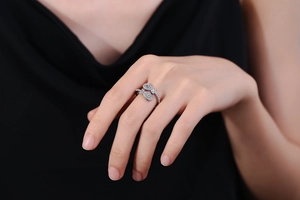 Detailed view of silver interlocking ring with blue evil eye stones on model