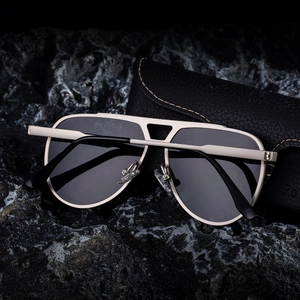Classic aviator sunglasses with metal frame and leather case on black stone background